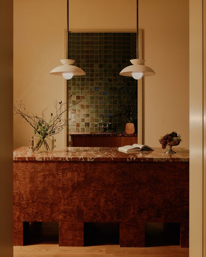 Marble counter with a burl wood base in a foyer area