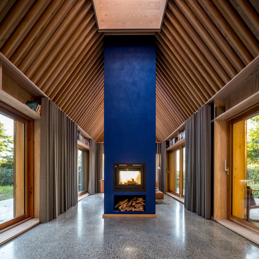 Blue hearth and timber ceiling beams inside The Author's House by Sleth