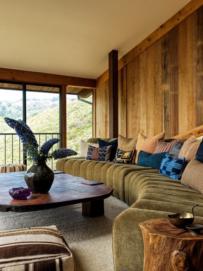 Living room with redwood panelling, curved sofa and large walnut coffee table