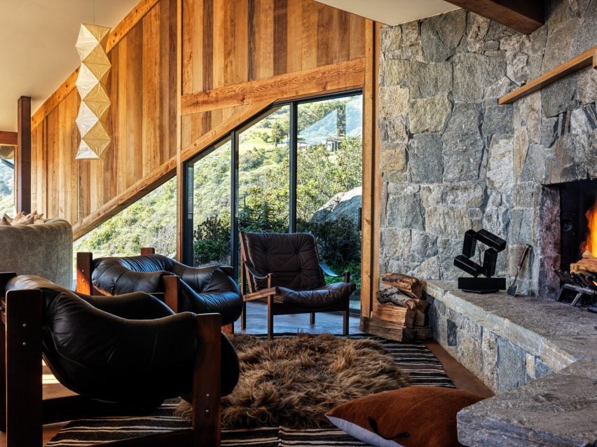 Vintage leather chairs surround an impressive stone hearth