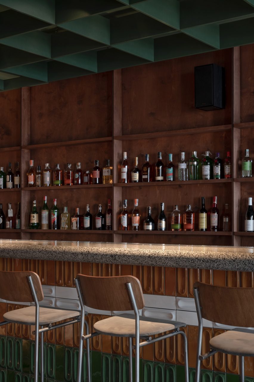 Bar counter clad in ochre, white and dark green relief tiles by Mirzoyan Studio