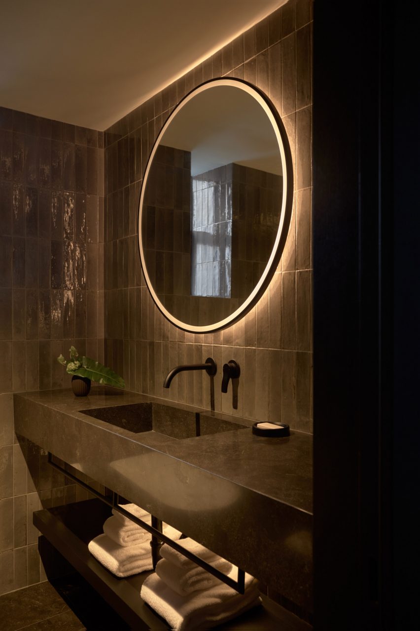 Guest bathroom lined with dark stone and tiles