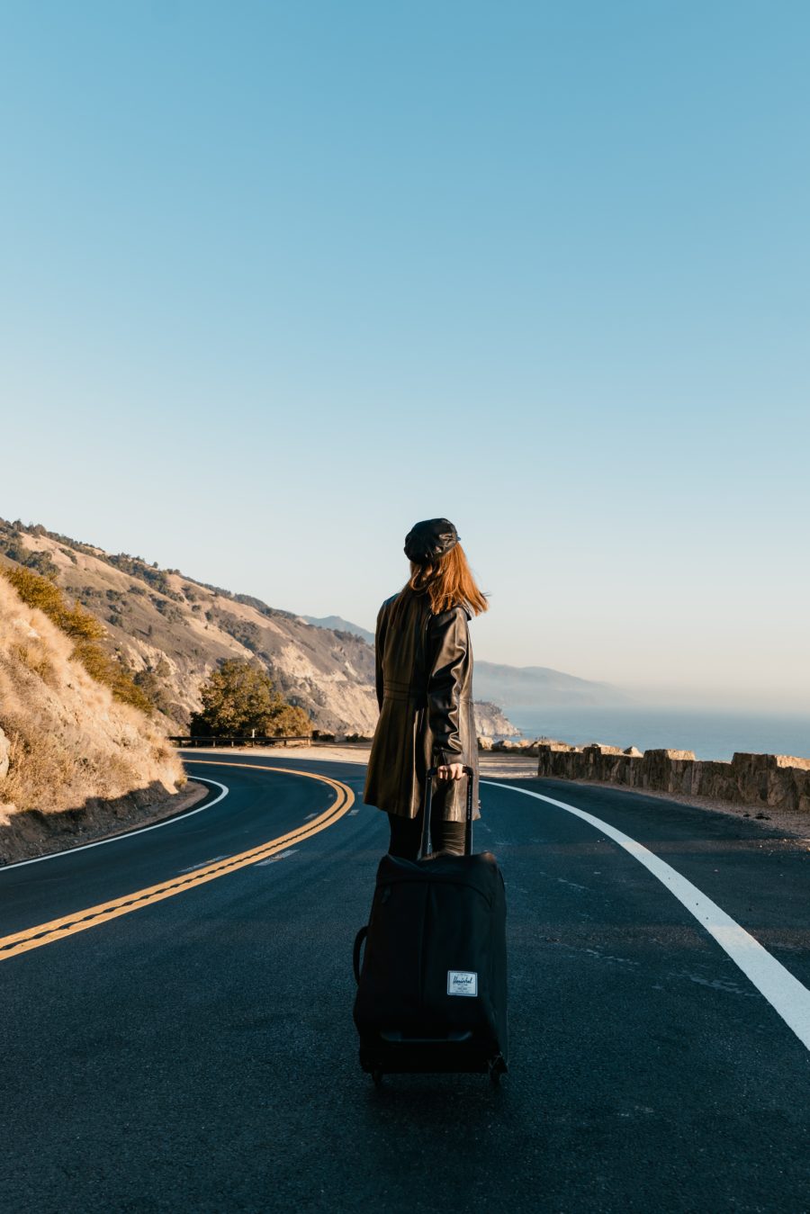 Woman with a suitcase on a highway