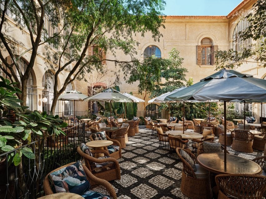 Central courtyards with tables, chairs and parasols amongst greenery