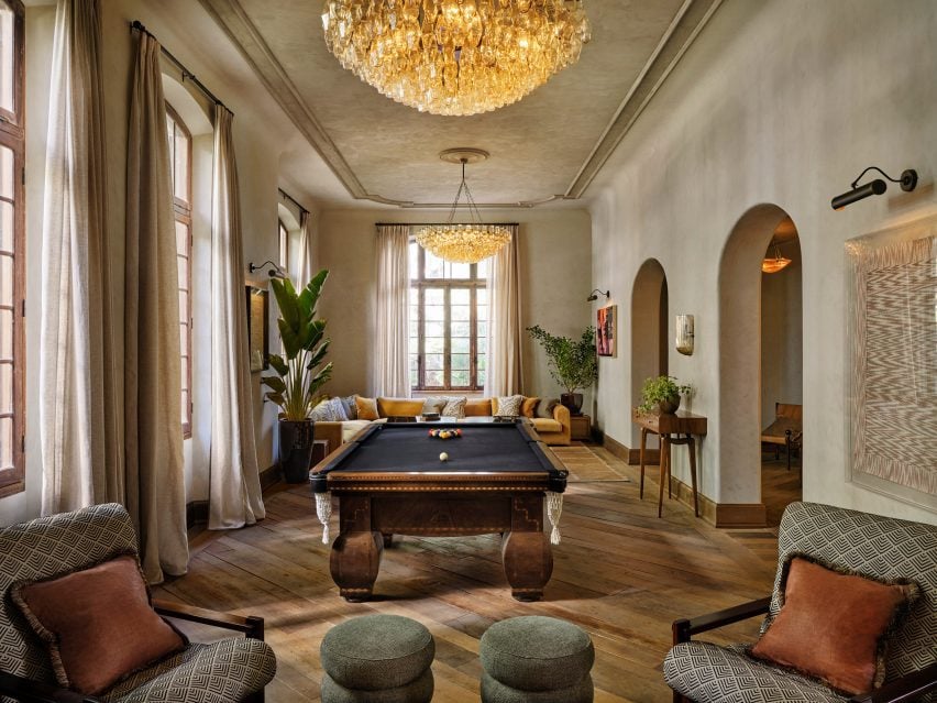 Game room with a navy-topped pool table and a large yellow sectional