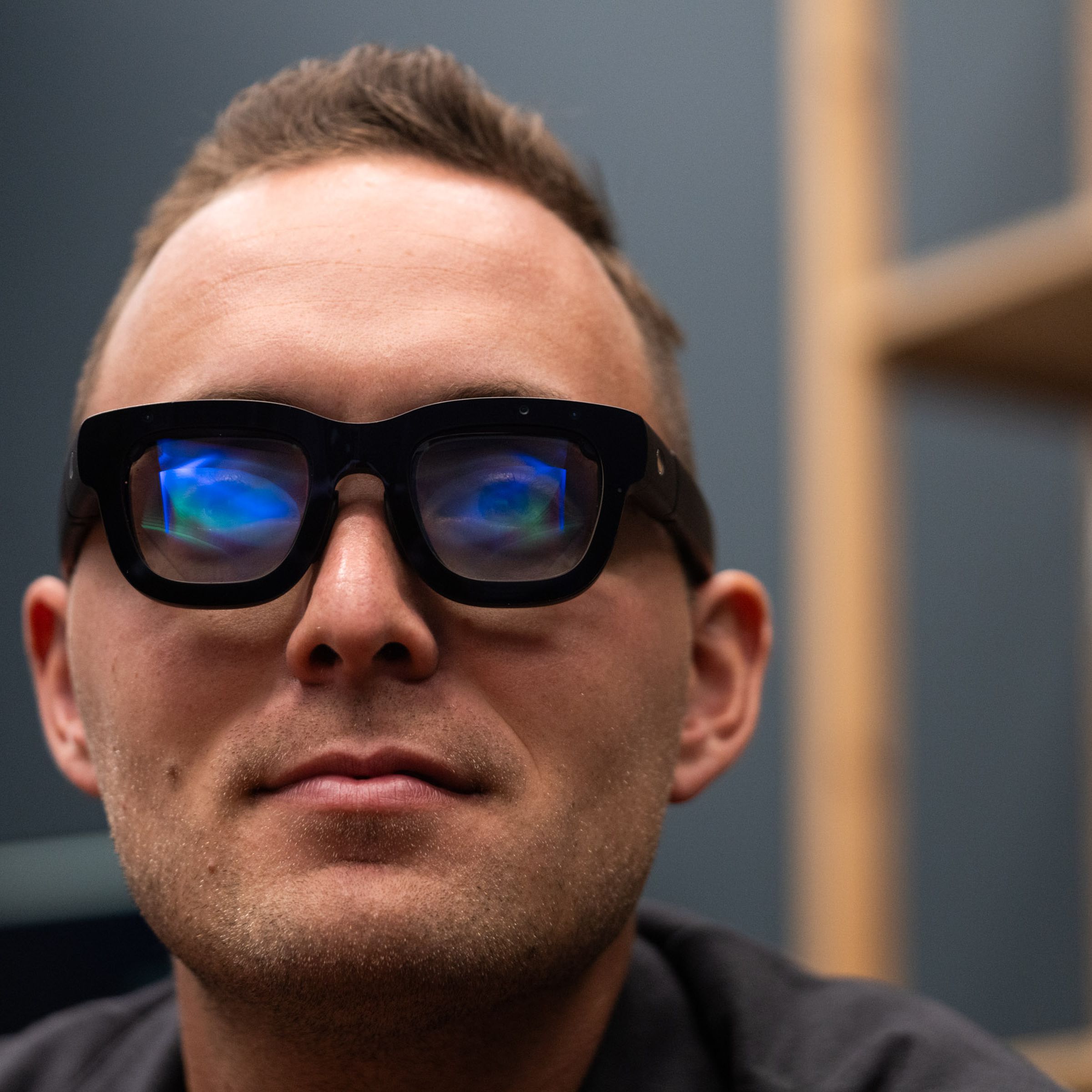 A person wearing a pair of Orion smart glasses facing the camera