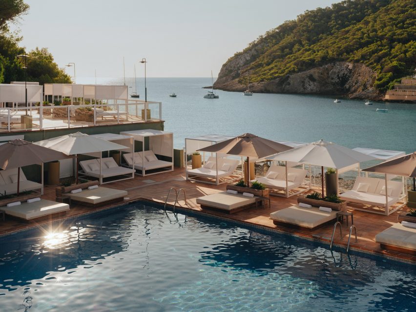 Swimming pool surrounded by cabanas with bay in the background