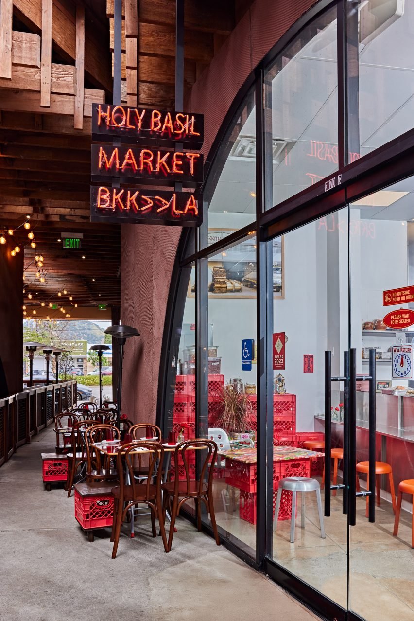 Exterior of Holy Basil Market with outdoor seating below a neon sign