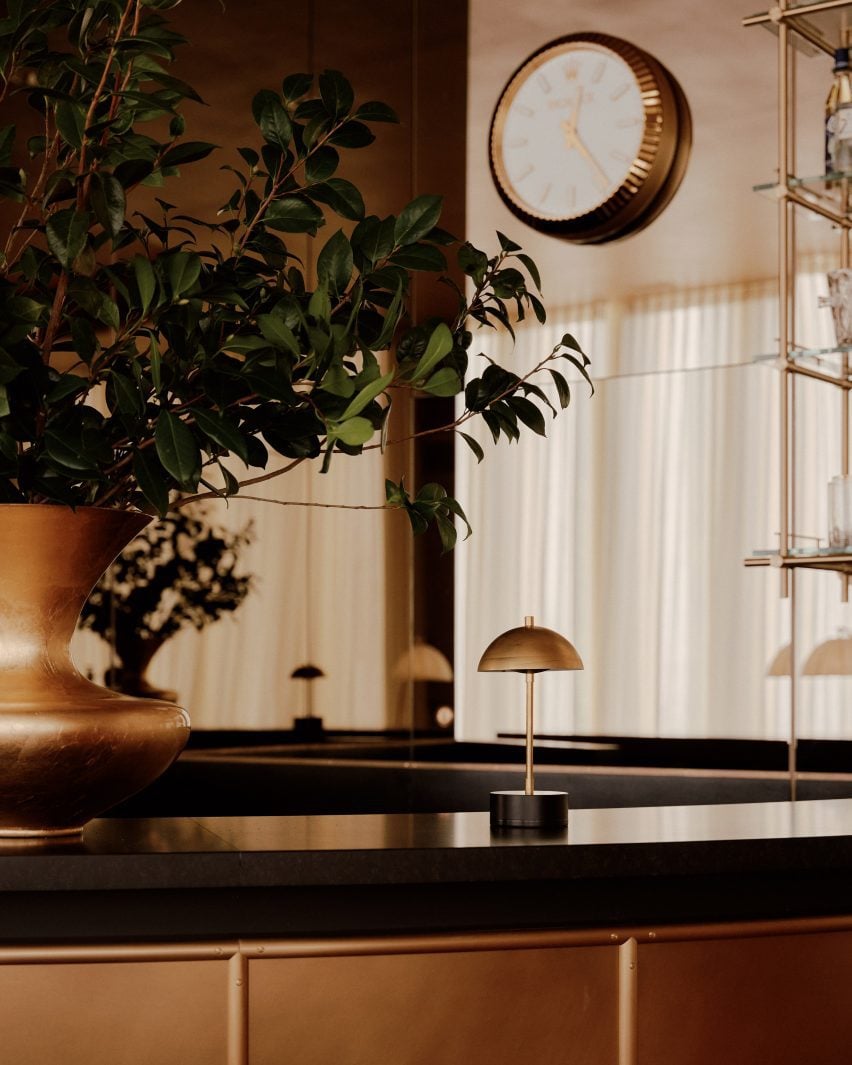 Small brass lamp atop a black bar counter