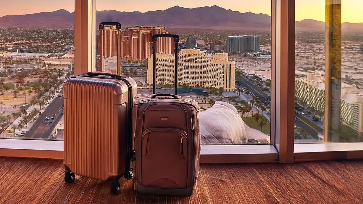 Two suitcases in front of a big window with a few of Las Vegas iconic hotels in the background.