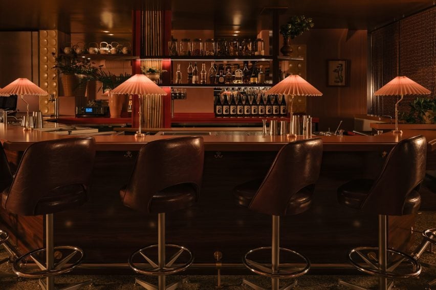 Leather-wrapped bar stools lined up in front of a wood-panelled bar