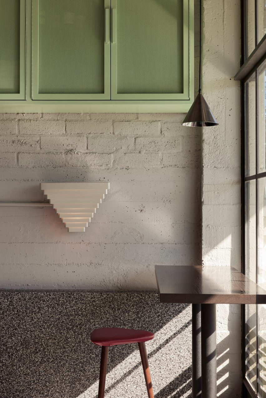 Sconces shaped like an inverted stepped pyramid mounted on a whitewashed brick wall