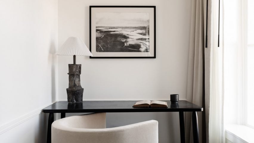 A cosy workspace nook with black wood table beside a window