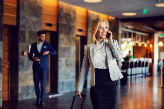 Happy businesswoman on a business trip walking in the hall of the hotel and talking on the phone. Luxury, business, telecommunications, a business first,euphoria