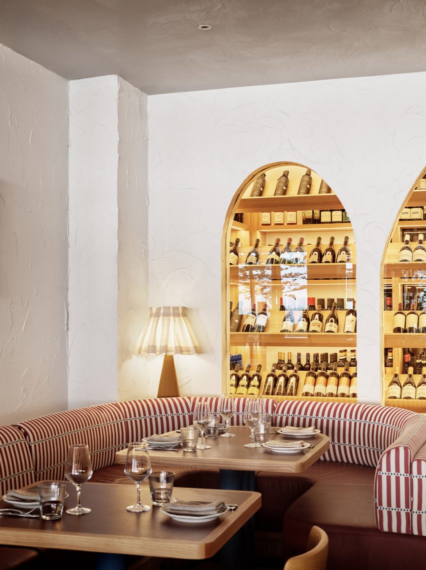 Red and white striped banquette and illuminated wine display cabinet