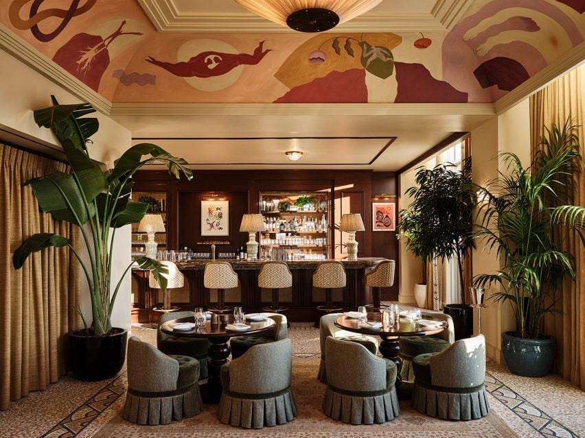 Restaurant with a ceiling mural and large plants