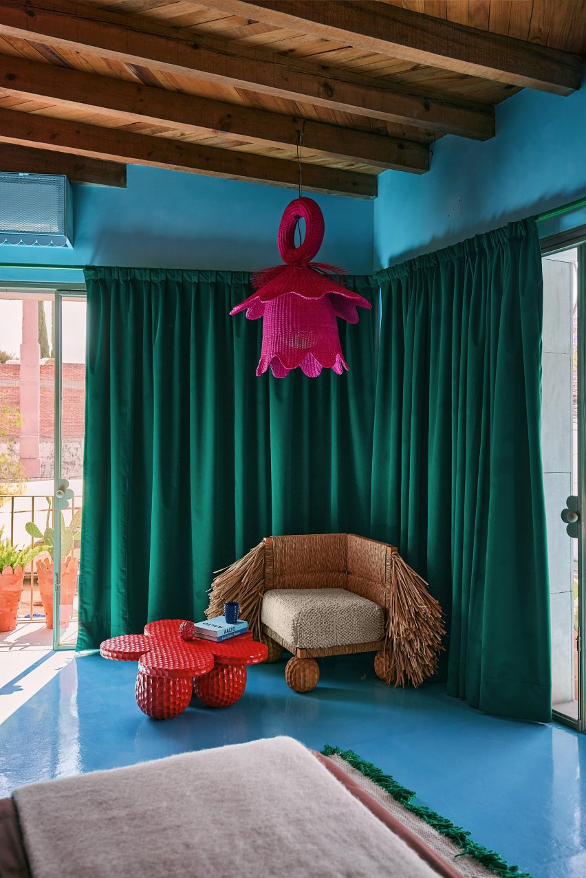 Room corner with green curtains against blue walls and floor