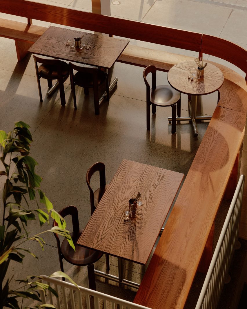 An aerial view over wooden tables arranged around a curve-cornered bench