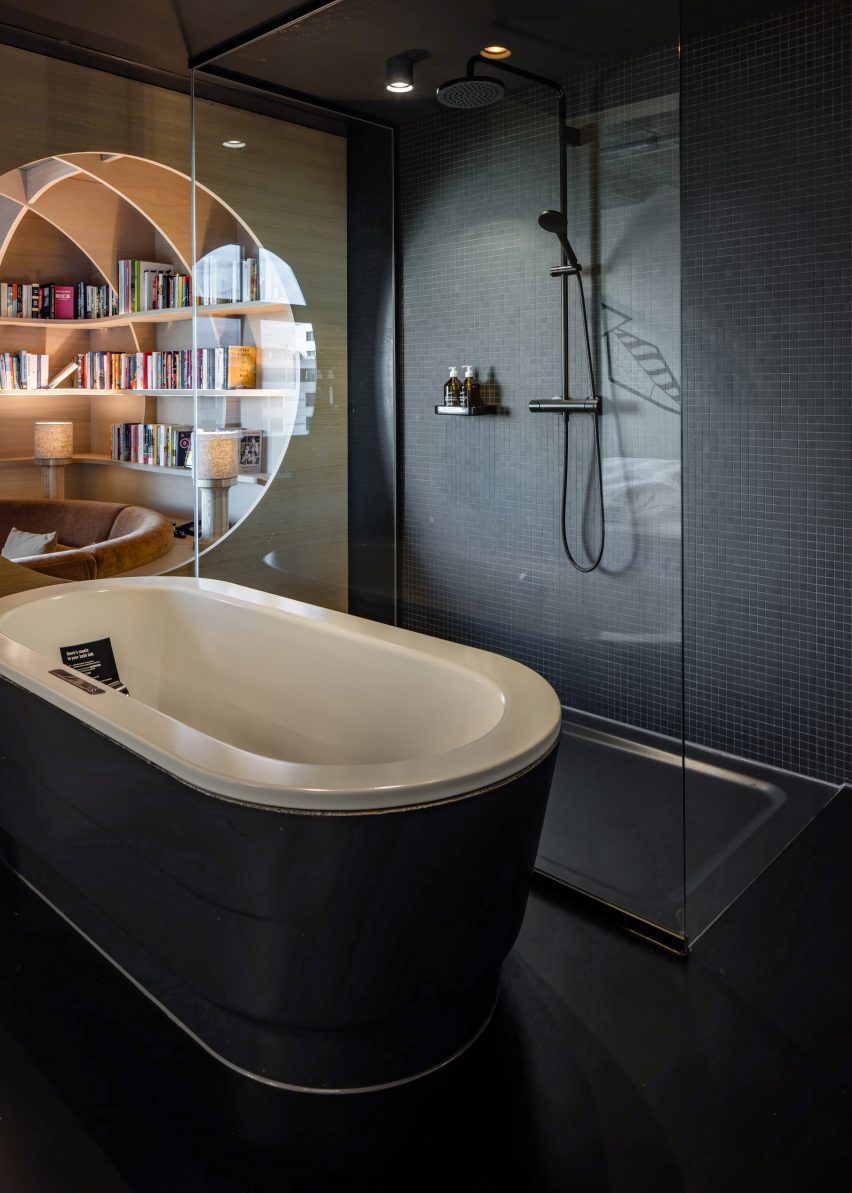 Black tiled bathroom in hotel renovation by Studio Aisslinger