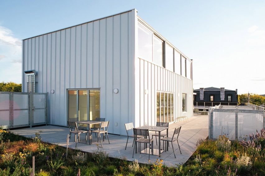 Simple metal-clad structure surrounded by a planted terrace