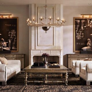 Luxurious living room with cream sofas, oversized abstract paintings, a grand fireplace, and a central crystal chandelier.