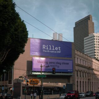 City street with a large purple billboard reading 'Rillet The AI-native ERP' above storefronts,Jackson Street sign, and tall office buildings to the right.