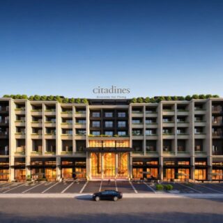 Citadines Riverside Hai Phong hotel façade with balconies, greenery on the roof, and a glass entrance by the river.