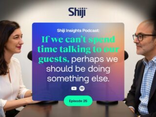 Two people sit across from each other in a podcast studio, with a colorful promo card in between that reads: “Shiji Insights Podcast: If we can’t spend time talking to our guests, perhaps we should be doing something else.” Episode 25 badge visible below.