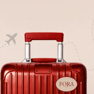 Red hard-shell suitcase with a white FORA brand sticker on the front, set against a beige background with a faint dashed airplane trail.