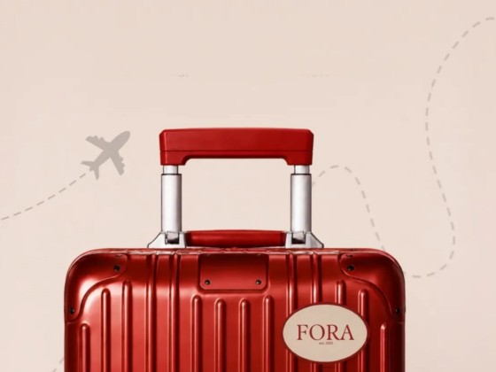 Red hard-shell suitcase with a white FORA brand sticker on the front, set against a beige background with a faint dashed airplane trail.