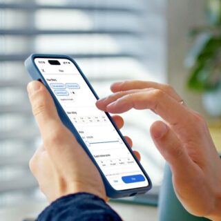 Person holding a smartphone showing a travel app on screen, with Agoda logo in the blurred background.