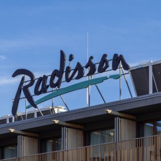 Radisson hotel sign atop a rooftop against a clear blue sky. (informative)