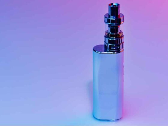 Silvery vape mod standing upright on a blue-pink gradient background.