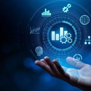Hands under a glowing circular holographic interface with charts, gears, and globe—symbolizing data analytics and digital tech.