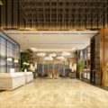 Luxurious hotel lobby with marble floors, a white reception desk, and seating area under cloud-shaped pendant lights.