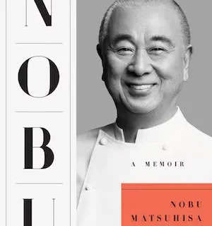 Book cover showing a black-and-white photo of Nobu Matsuhisa smiling on a gray background, with vertical 'NOBU' letters on the left and an orange rectangle containing 'NOBU MATSUSHISA' beneath a small 'A MEMOIR' subtitle.