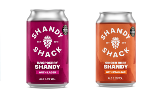 Four Shandy Shack cans in a row: Lemon Shandy (blue), Raspberry Shandy (magenta), Ginger Beer Shandy (orange), Elderflower Shandy (green‑teal) with branding visible.