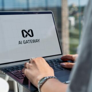Close-up of hands typing on a laptop screen displaying the AI Gateway logo.