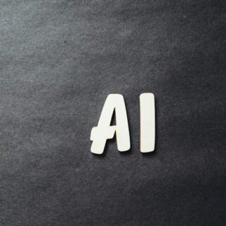 Two light wooden letter A shapes positioned together on a dark textured background.