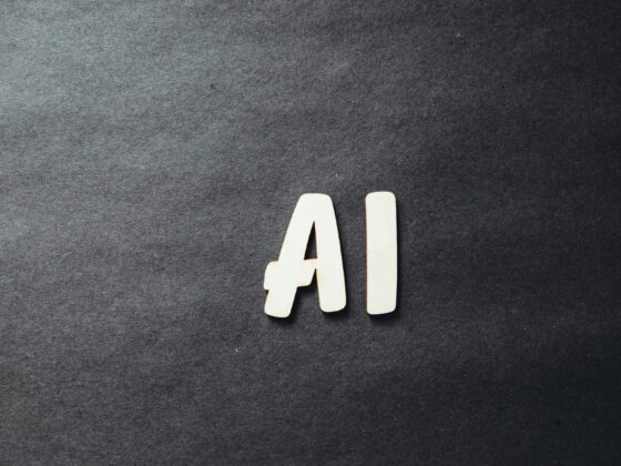 Two light wooden letter A shapes positioned together on a dark textured background.