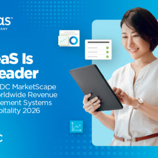 Smiling woman in a light blouse holds a tablet against a blue gradient banner; headline reads: "IDeas Is a Leader in the IDC MarketScape for Worldwide Revenue Management Systems in Hospitality 2026" with IDC logo.