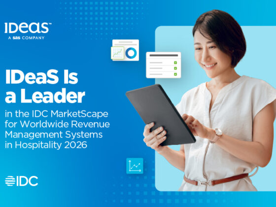 Smiling woman in a light blouse holds a tablet against a blue gradient banner; headline reads: "IDeas Is a Leader in the IDC MarketScape for Worldwide Revenue Management Systems in Hospitality 2026" with IDC logo.