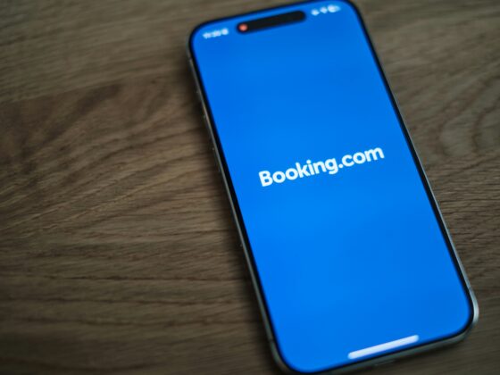Close-up of a smartphone screen showing the Booking.com app on a bright blue background.