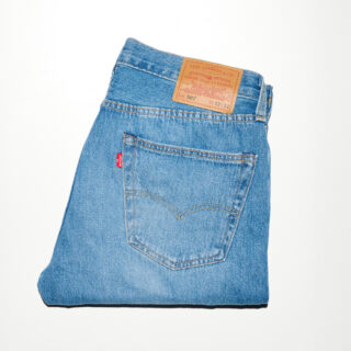 Back pocket of blue denim jeans with a red Levi's tag and tan leather patch near the waistband area.