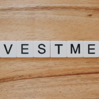 Tiles spell out the word INVESTMENT on a wooden surface