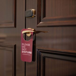 Door with a purple 'Please Do Not Disturb' tag hanging from the doorknob