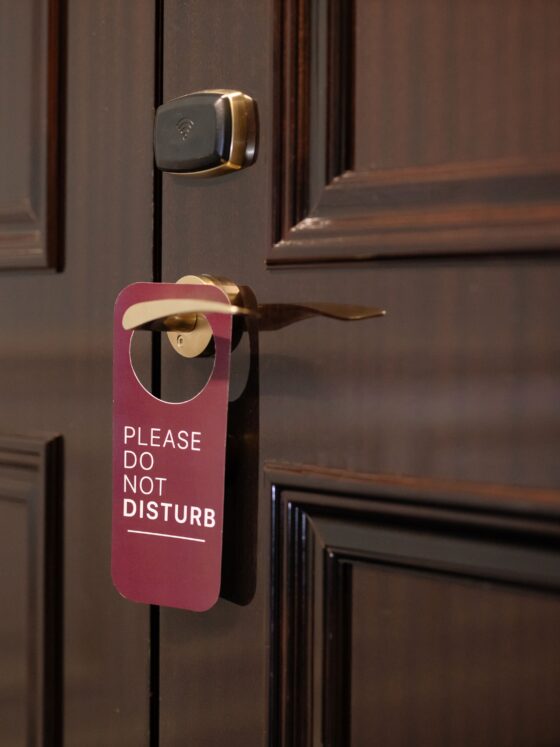 Door with a purple 'Please Do Not Disturb' tag hanging from the doorknob