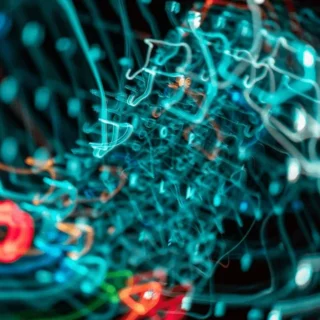 Blurred close-up of tangled blue and red network cables, suggesting chaotic data wiring in a tech setup.