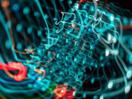 Blurred close-up of tangled blue and red network cables, suggesting chaotic data wiring in a tech setup.