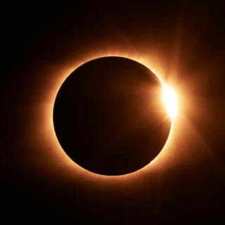 Solar eclipse: the Moon blocks the Sun, leaving a bright solar corona around a dark disk.